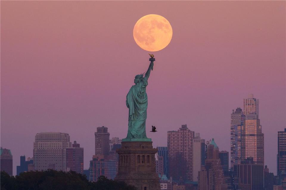 Der Supermond geht hinter der Freiheitsstatue in New York auf.Adam Gray/AP/dpa