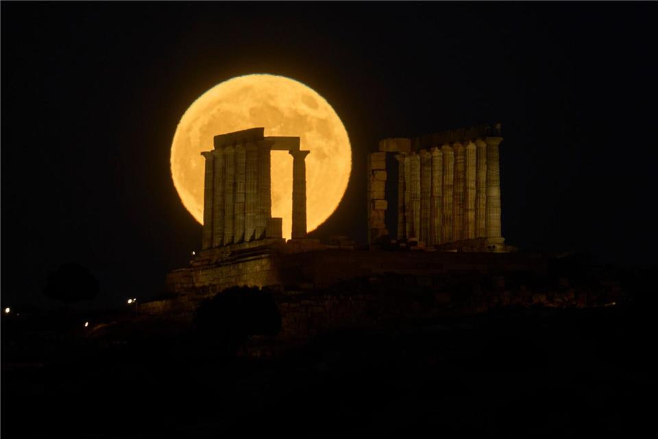 Der Vollmond steht hinter dem antiken Poseidon-Tempel am Kap Sounion in Griechenland.Petros Giannakouris/AP/dpa