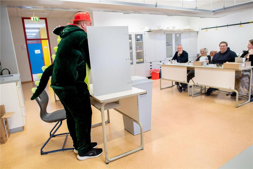 Der Wähler Christopher hat sich als Dinosaurier verkleidet.Hauke-Christian Dittrich/dpa