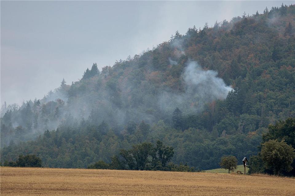 Der Waldbrand in Freudenberg ist unter Kontrolle, doch die Löscharbeiten in dem unwegsamen Gelände dauern an. Tizian Gerbing/dpa
