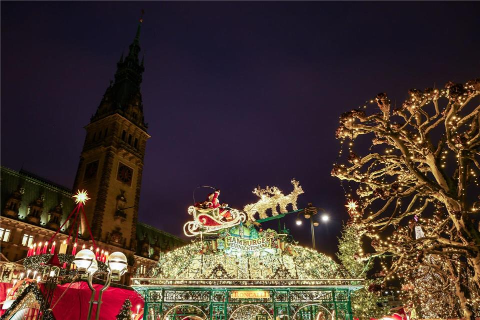 Der Weihnachtsmarkt am Rathaus ist hell erleuchtet. Christian Charisius/dpa