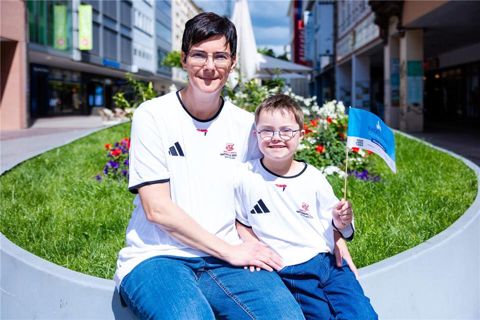 Der achtjährige Elias steht zusammen mit seiner Mutter in der Saarbrücker Bahnhofstraße kurz vor seinem großen Auftritt beim Fackellauf der Special Olympics.Laszlo Pinter/dpa
