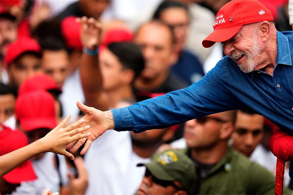 Der brasilianische Präsident Luiz Inácio Lula da Silva, der sich um eine Wiederwahl bewirbt, begrüßt einen Anhänger während seiner letzten Wahlkampfveranstaltung in São Paulo einen Tag vor der Stichwahl um das Präsidentenamt.Natacha Pisarenko/AP/dpa