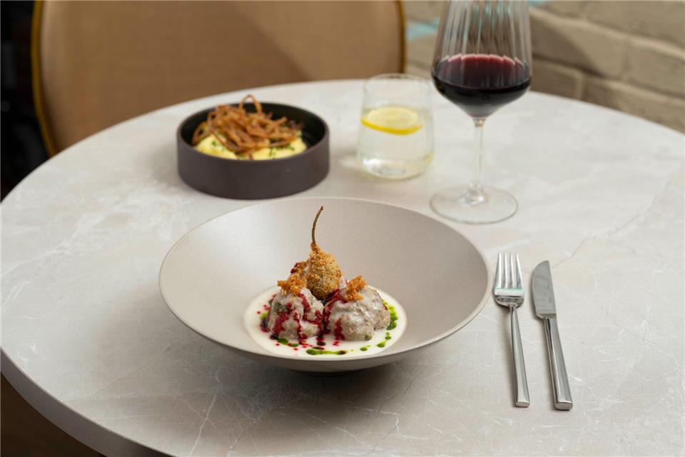 Der frittierte Kapernapfel und die Tröpfchen von dem eingekochten Rote-Bete-Sirup geben den Königsberger Klopsen zusätzlich Textur sowie Crunch und sorgen für ein Spiel mit Säure-Nuancen.Florian Bolk/Leonardo Hotels Central Europe/dpa-tmn