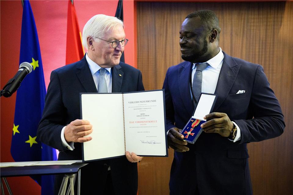 Der frühere Fußball-Nationalspieler Gerald Asamoah (r) erhält von Bundespräsident Frank-Walter Steinmeier das Bundesverdienstkreuz.Bernd von Jutrczenka/dpa