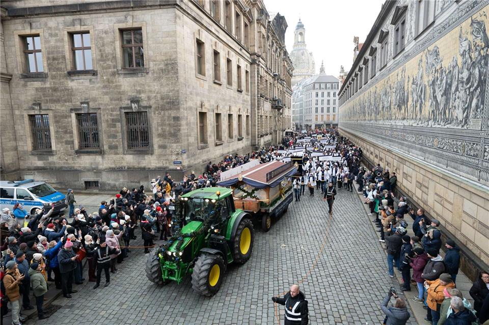 Der mehr als 2 Tonnen schwere Riesenstollen wird auf einem Wagen am Fürstenzug vorbei durch das historische Dresdner Stadtzentrum gefahren.Sebastian Kahnert/dpa