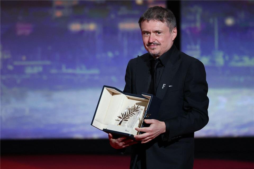 Der rumänische Regisseur, Drehbuchautor und Produzent Cristian Mungiu feiert auf der Bühne nach dem Gewinn der Goldenen Palme für seinen Film „Fjord“ bei der Abschlusszeremonie der 79. Ausgabe der Filmfestspiele von Cannes.Sameer Al-Doumy/AFP/dpa