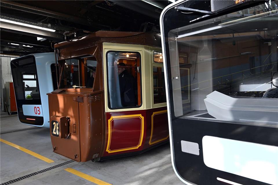 Der sogenannte Kaiserwagen der Wuppertaler Schwebebahn steht zwischen Fahrtzeugen der aktuellen Generation in der Wagenhalle. Federico Gambarini/dpa