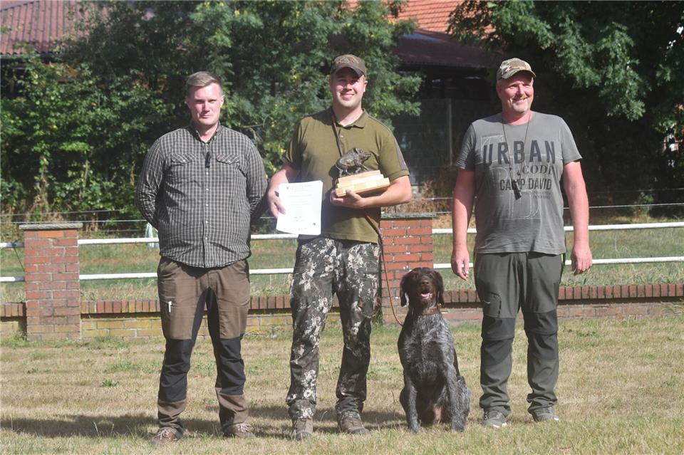 Der stellvertretende Obmann Hundewesen Hendrik Dirking (l.) und Hegeringsleiter Matthias Höbing-Rensing (r.) gratulieren Sieger Franz Kremer.