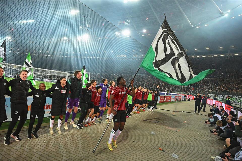 Derby-Jubel nach dem 1:0 gegen Braunschweig. Hannovers Mustapha Bundu schwenkt vor der Fankurve die 96-Fahne.Swen Pförtner/dpa