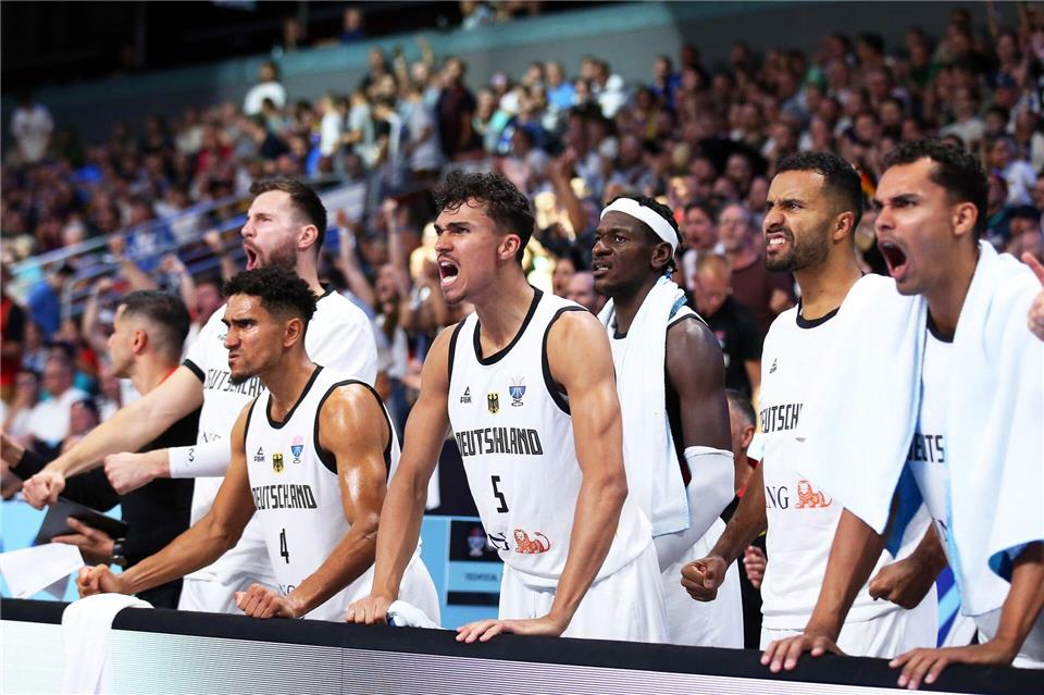 Deutschlands Spieler um Tristan Da Silva (M) reagieren während des Spiels gegen Slowenien bei der Basketball-EM auf der Bank.Matthias Stickel/dpa
