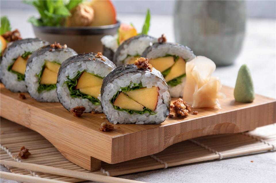 Die Algenblatt- und Reisgrundlage von Maki-Sushi kann jeweils saisonal passend gefüllt werden: hier mit Pfirsich und Basilikum.Alex Neumayer/Christian Verlag/dpa-tmn