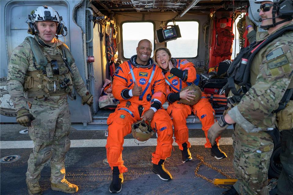 Die Astronauten Victor Glover und Christina Koch sitzen auf einem Hubschrauber der Navy auf dem Flugdeck des Schiffs USS John P. Murtha, nachdem sie aus ihrem „Orion“-Raumschiff geholt wurden.Bill Ingalls/NASA/AP/dpa