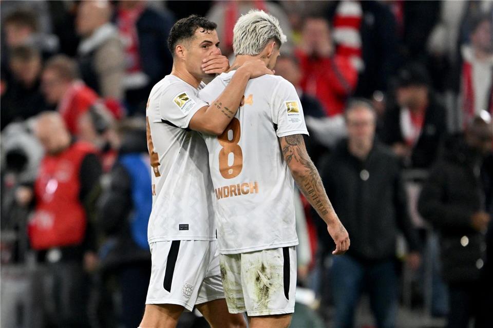 Die Bayer-Profis Granit Xhaka (links) und Robert Andrich sind zufrieden über das 1:1 in München.Peter Kneffel/dpa