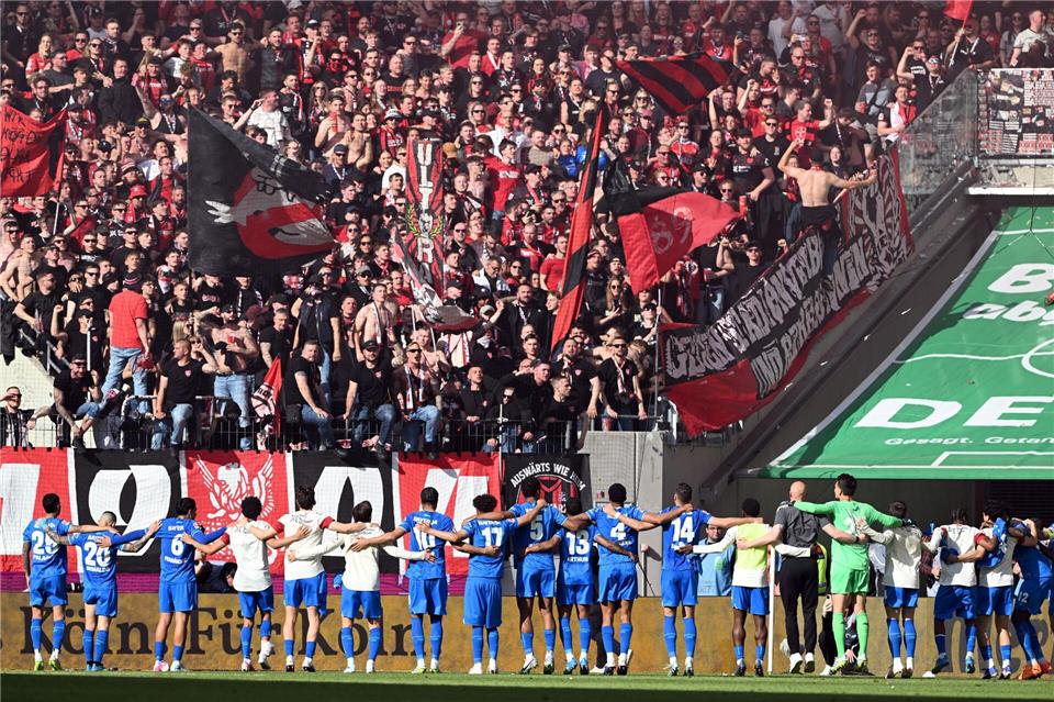 Die Bayer-Spieler feiert mit den Fans den Sieg im Derby gegen Köln. Federico Gambarini/dpa