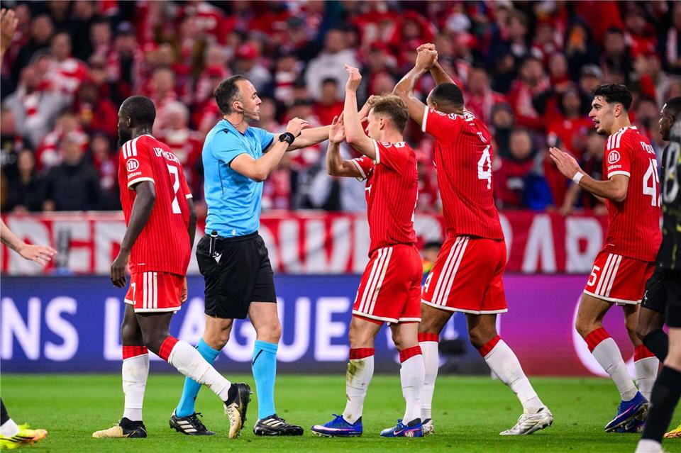 Die Bayern-Profis Joshua Kimmich und Jonathan Tah (M) bestürmen aufgebracht Schiedsrichter João Pinheiro. Tom Weller/dpa