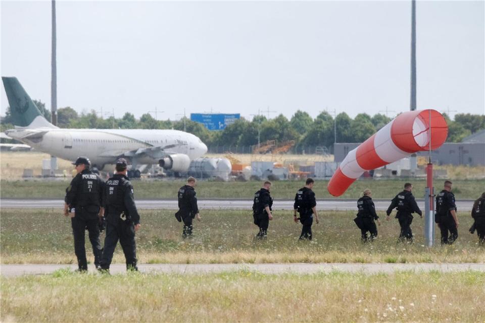 Die Beamten suchen das Gelände zu Fuß ab. Sebastian Willnow/dpa