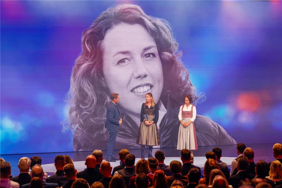 „Das Leben ist zu kurz“ – Biathletinnen würdigen Dahlmeier Die Biathletinnen Franziska Preuß und Magdalena Neuner (hier mir Moderator Markus Othmer vor einem Bild von Laura Dahlmeier) haben bei der Verleihung des Bayerischen Sportpreises ihrer gestorbenen Kollegin Dahlmeier gedacht. Alexandra BEIER/BayStMI/dpa