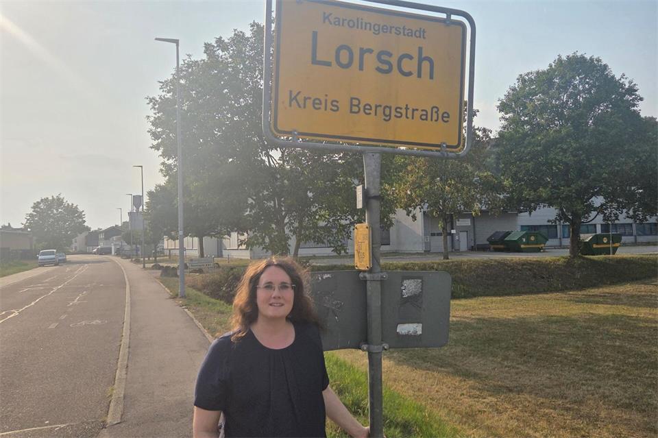 Die Bürgermeisterin von Lorch im Ostalbkreis, Marita Funk, neben dem vertauschten Schild der hesssischen Gemeinde Lorsch.-/Stadt Lorch/dpa