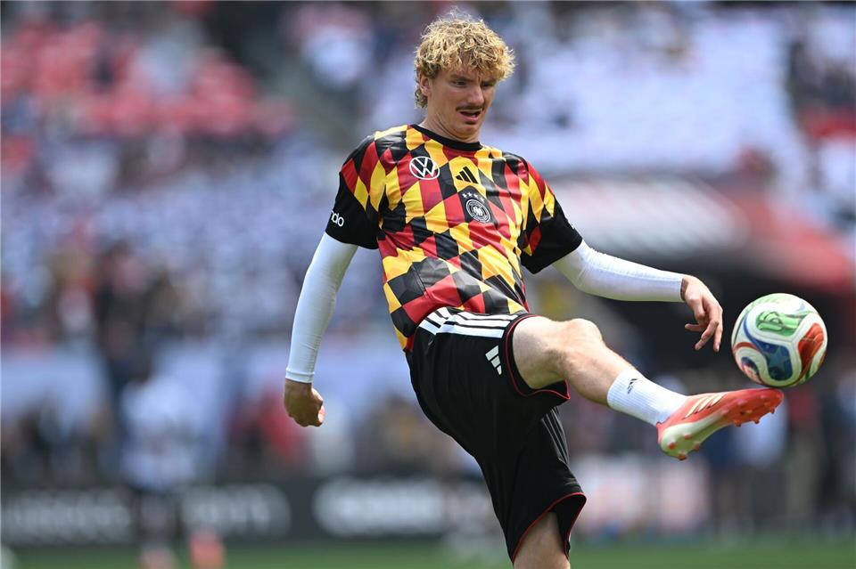 Die DFB-Spieler um Nick Woltemade wärmten sich in auffälligen Shirts auf.Federico Gambarini/dpa