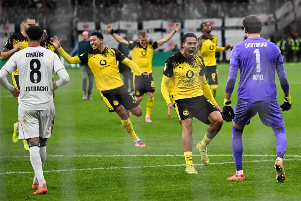 Elfmeterkrimi: BVB besiegelt frühes Pokal-Aus für Frankfurt  Die Dortmunder Spieler stürmen auf Elfmeter-Held Kobel zu.Arne Dedert/dpa