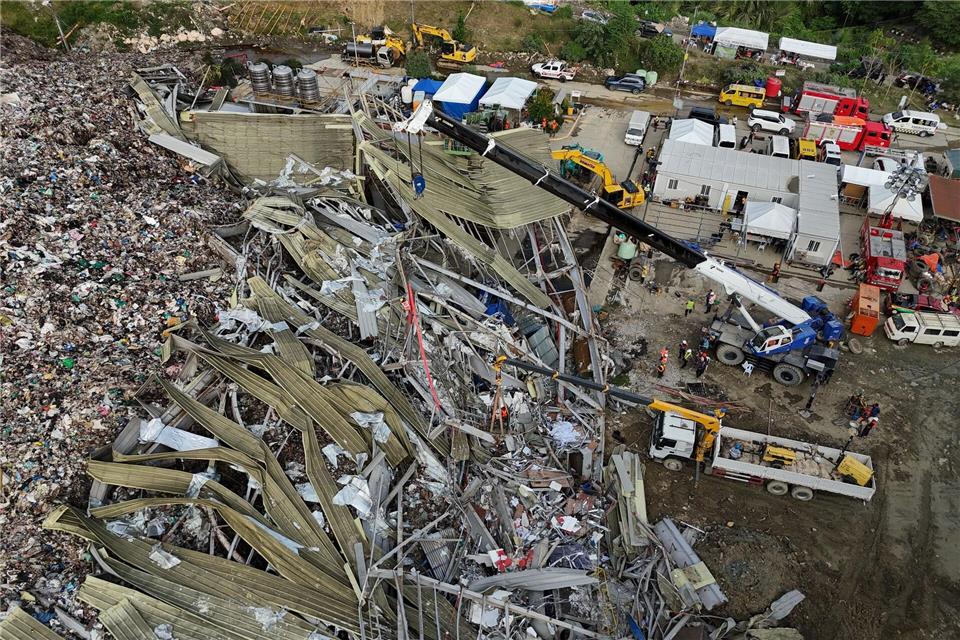 Die Einsatzkräfte suchen unter anderem mit einem Kran in den Abfall-Massen.Jacqueline Hernandez/AP/dpa