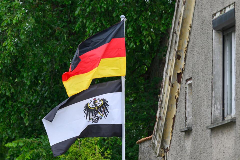 Die Fahne von Deutschland und eine Dienstflagge von Preußen aus der Zeit von 1892 wehen auf einem Grundstück. (Symbolbild)Patrick Pleul/dpa
