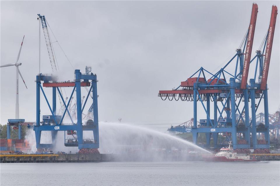Die Feuerwehr ist auf einem Container-Terminal in Hamburg mit den Löscharbeiten beschäftigt. Marcus Golejewski/dpa