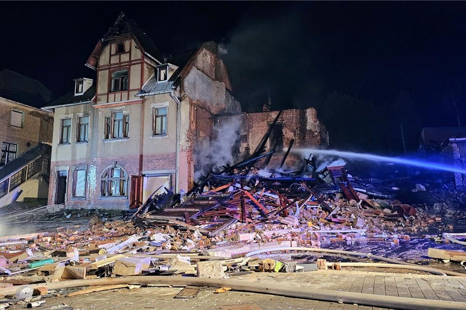Brand zerstört Häuser - Undichte Gasleitung mögliche Ursache Die Feuerwehr löscht die Reste eines explodierten Hauses.