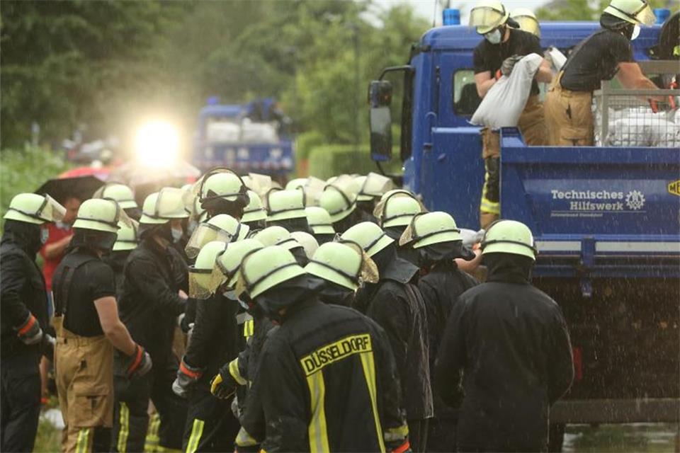 Die Feuerwehr versucht, die Wassermassen mit Sandsäcke zu stoppen. Foto: David Young/dpa