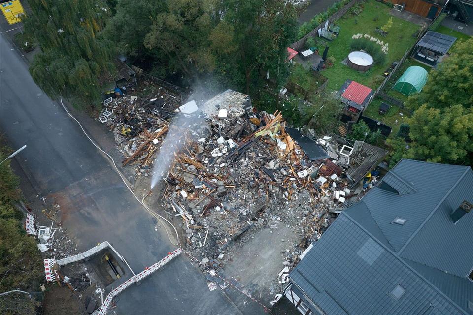 Die Feuerwehr wässerte die Unglücksstelle, um gegen mögliche Glutnester unter den Trümmern vorzugehen. Thomas Frey/dpa