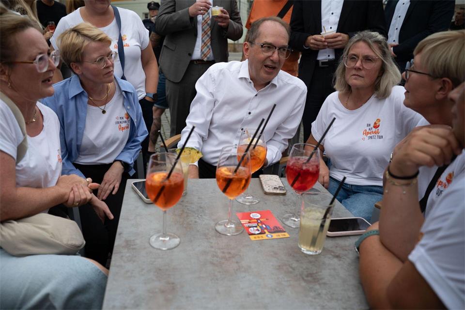 Die Freundinnen, die sich regelmäßig treffen, nehmen Bundesinnenminister Alexander Dobrindt (CSU) in ihre Mitte.Katharina Kausche/dpa pool/dpa