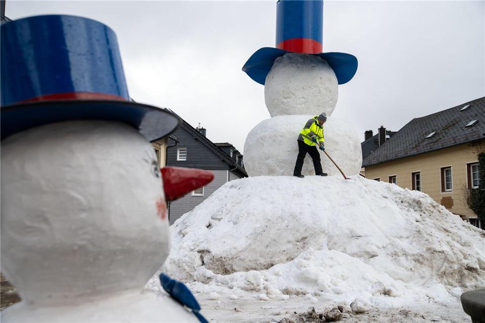 Die Handgriffe zum Bau des XXL-Schneemanns „Jakob“ sitzen.Pia Bayer/dpa