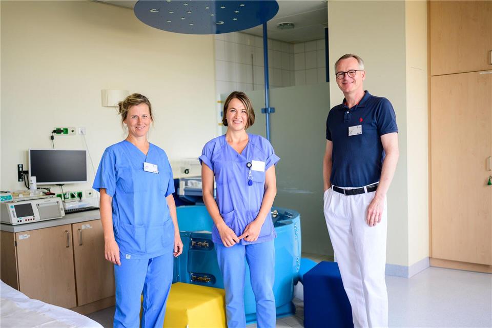 Die Hebammen Franziska Pfeil (l-r) und Antje Kuhrau sowie Peter Dall, Chefarzt, stehen in einem Kreißsaal des Klinikums Lüneburg. Seit diesem Monat können Frauen in Begleitung von zwei Hebammen entbinden.Philipp Schulze/dpa