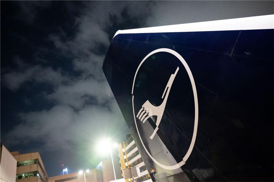 Die Heckflosse einer Lufthansa-Maschine ragt vor dem Verwaltungsgebäude in Frankfurt in den Himmel.