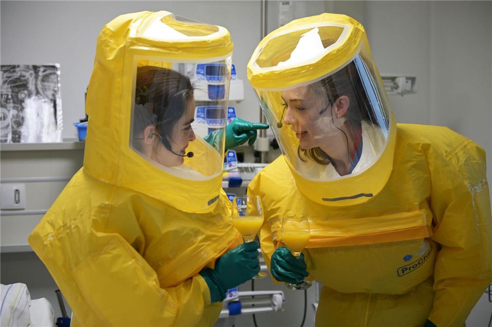 Die Helfer müssen sich per Sprechfunk verständigen - in den Anzügen hören sie sonst nichts. Malin Wunderlich/dpa