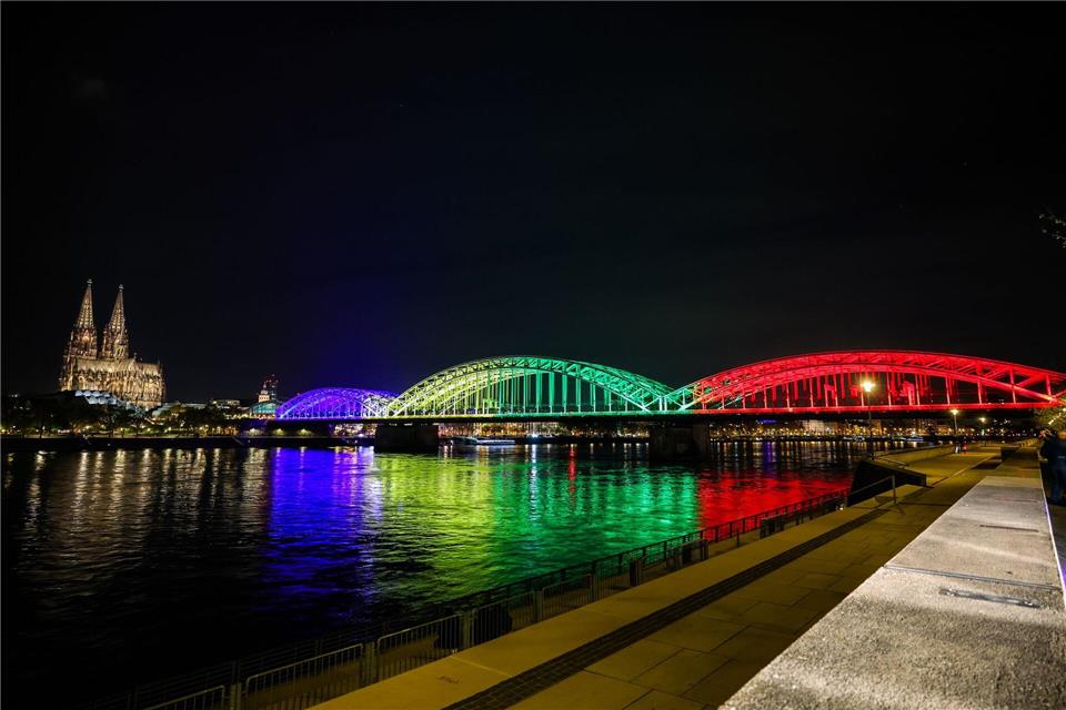 Die Hohenzollernbrücke leuchtet in den olympischen Farben.Christoph Reichwein/dpa