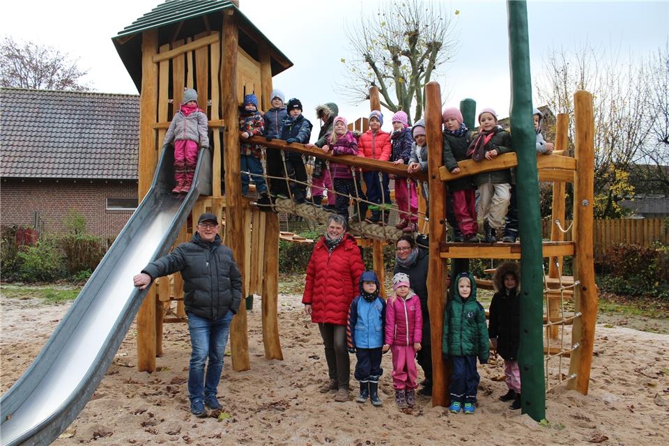 Die Jungen und Mädchen des evangelischen Lukas-Kindergartens freuen sich mit Bauamtsleiter Bernd Roters, Rita Flück von der Bauverwaltung und Kita-Leitern Heike Neumann über die Freigabe des umgestalteten Spielplatzes am Ahornpfad.