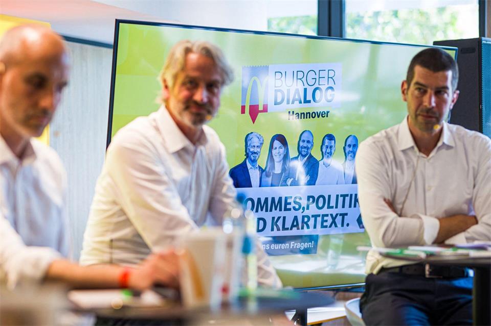 Die Kandidaten für die Oberbürgermeisterwahl 2026 in Hannover, Belit Onay (von links nach rechts, Grüne), Peter Karst (CDU) und Axel von der Ohe (SPD) nehmen am „Burger Dialog Hannover“ in der Filiale einer Fast-Food-Kette teil.Moritz Frankenberg/dpa