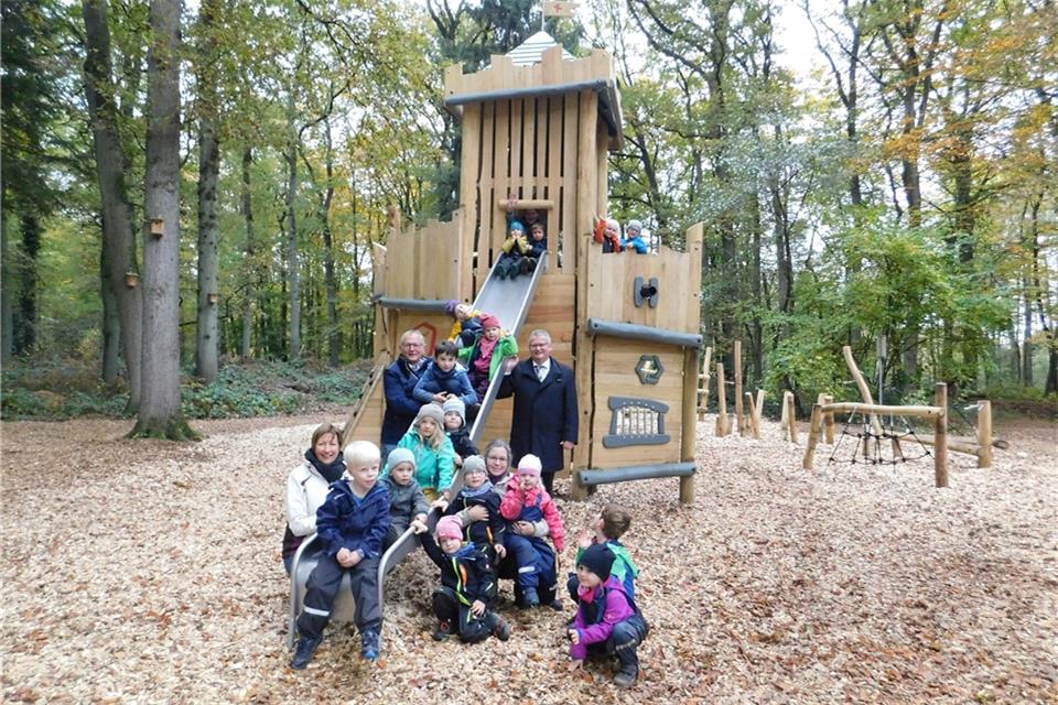 Die Kinder der Kita „Waldwurm“ freuen sich mit Gruppenleiterin Andrea Reining, Bauamtsleiter Bernd Roters, Erzieherin Anna-Rebecca Berger und Bürgermeister Martin Tesing (v. l.) über die neuen Spielgeräte auf dem Naturerlebnisgelände.