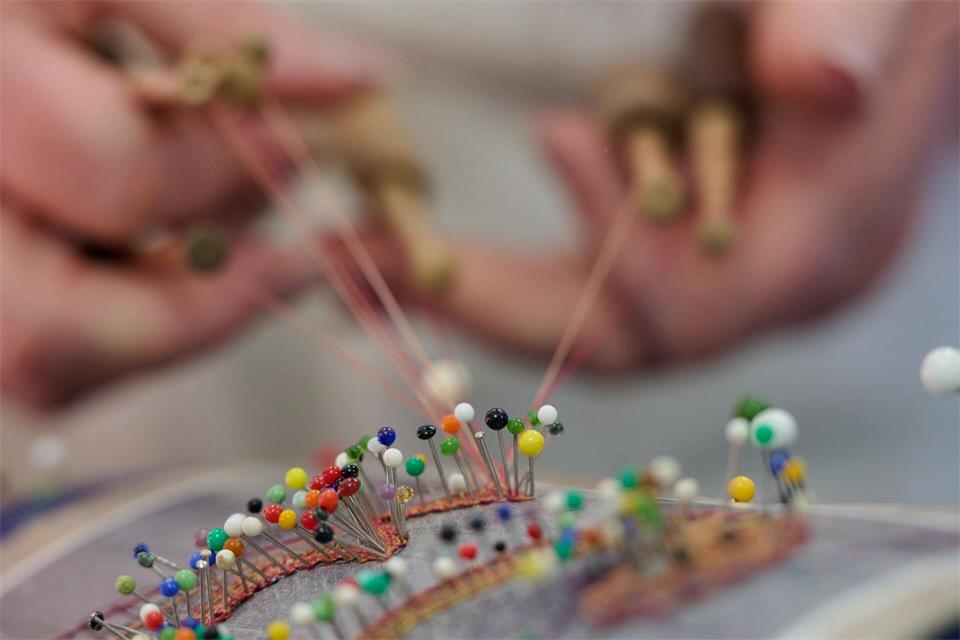 Die Klöppelarbeit wird mit Stecknadeln fixiert.Katharina Kausche/dpa