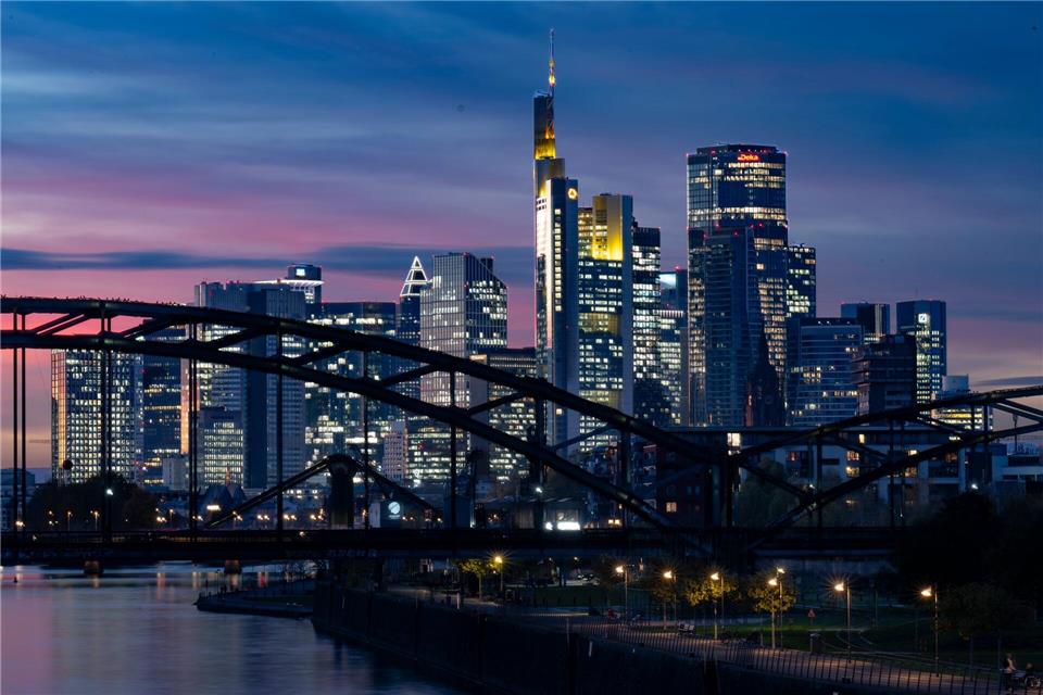 Die Lichter der Bankenskyline von Frankfurt leuchten in der Abendstimmung.Boris Roessler/dpa
