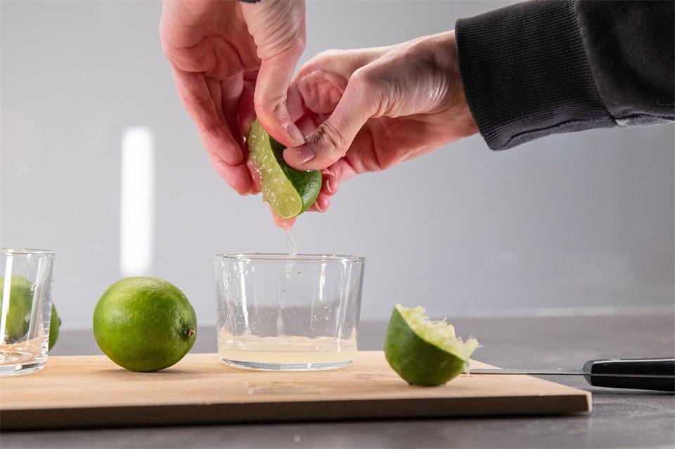 Die Limettenhälften mit der Hand auspressen.Christin Klose/dpa-tmn