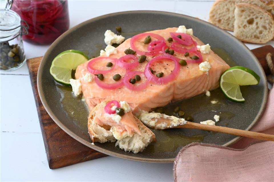 Die Marinade zum gegrillten Lachs sorgt für ein buttrig-süßes Aroma und bildet einen wunderbaren Kontrast zu den sauer eingelegten Zwiebeln und den salzigen Kapern. Julia Uehren/dpa-tmn