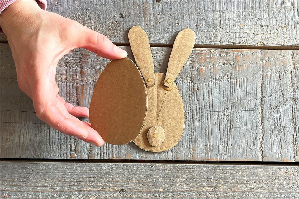 Die Ohren und den Kreis auf dem Hasenkörper anbringen, dann den zweiten Karton oben draufkleben.DIY Academy/dpa-tmn