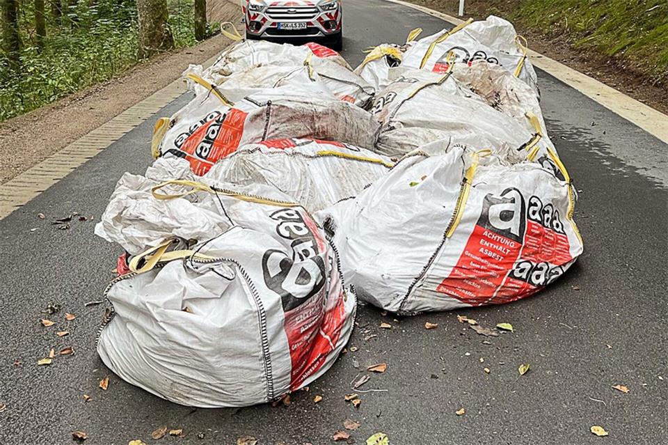 Die Polizei ermittelt nun, wer die Säcke auf der Landstraße im Wald abgestellt hat. -/KPB Hochsauerlandkreis/dpa