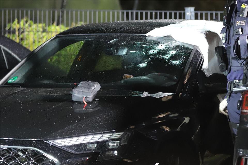 Die Polizei ist weiterhin am Tatort im Einsatz. Durch die Windschutzscheibe eines Wagens wurden Schüsse auf einen Mann abgegeben. Sascha Thelen/dpa