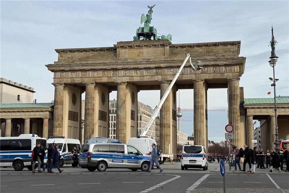 Die Polizei klettert auf das Brandenburger Tor in Berlin, um Demonstranten festzunehmen. Paul Zinken/dpa