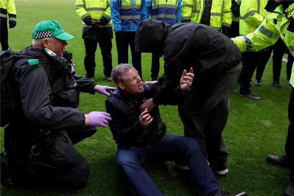 Die Polizei schritt ein, nachdem Celtic- und Rangers-Fans auf das Spielfeld liefen.Steve Welsh/PA/AP/dpa