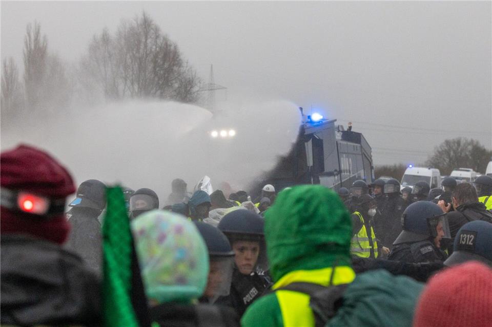 Die Polizei setzt Wasserwerfer gegen Demonstranten ein, die die B429 nahe der Lahnbrücke blockieren. Lando Hass/dpa